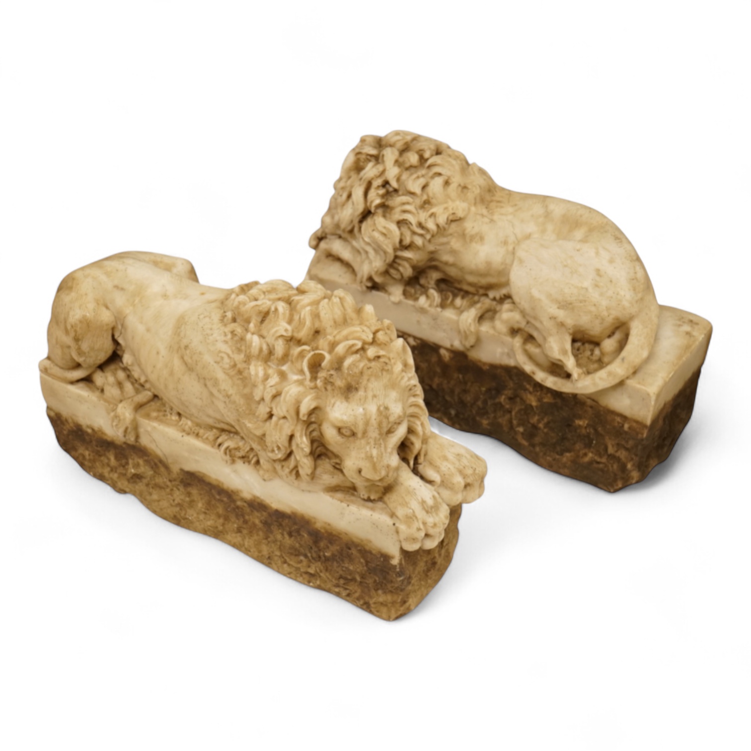 A pair of 20th century faux marble models of recumbent lions, 31cm